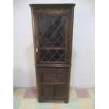 An oak corner cupboard with leaded light window