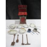 A collection of dolls house items including cooker, enamelled cookware and cast iron garden tools