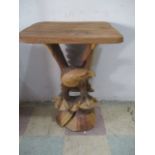 A carved occasional table the base formed as an eagle, height 71cm
