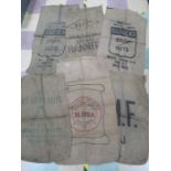 A collection of twelve hessian sacks, nine with advertising on, along with army kit bag