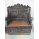 A 19th/early 20th century carved oak hall seat with cupboard under, the arms formed of dragons
