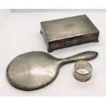 A hallmarked silver cigarette box, silver hand mirror along with a silver serviette ring