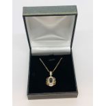 A 9ct gold pendant set with diamonds, ruby and sapphire on a 9ct gold chain