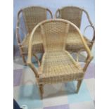 A pair of wicker chairs and one other similar