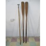 A pair of vintage wooden boat oars, along with a boat hook