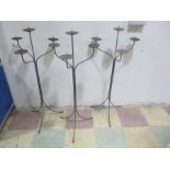A set of three wrought iron four branch candelabra, each approx. 100cm height