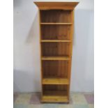 A tall narrow pine bookcase