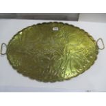 An arts & crafts brass oval tray with floral decoration, with initials K.M.F to front side