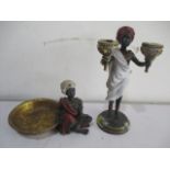 A 20th century resin figure of a Blackamore holding two candleholders along with one other