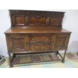 An oak Jacobean style sideboard, with barley twist supports and cupboard under.