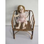 A pedigree 1950's hard plastic doll (height 48cm) on child's bamboo chair