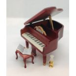 A dolls house grand piano, stool etc