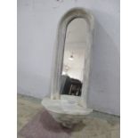 A painted mirror with scallop shaped shelf under