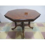 A turn of the century walnut inlaid octagonal table with quatrefoil base with brass detailing