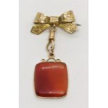 A Chester hallmarked pendant brooch with hardstone pendant below a two tone gold bow