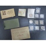 An assortment of vintage postcards, cigarette cards and commemorative coins