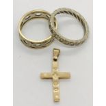 A 9ct gold Millennium cross, 9ct two tone wedding band and a 9ct gold eternity ring. Total weight