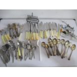 A collection of assorted cutlery along with a toast rack