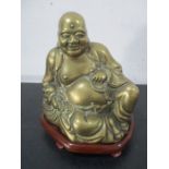 A brass Buddha on wooden plinth