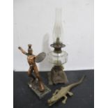 A converted oil lamp, Grecian warrior figure and a brass crocodile