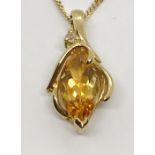 A 9 ct gold pendant set with a marquise shaped citrine and a diamond