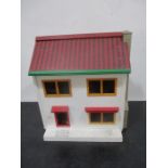A dolls house with sliding front panel, containing various items of furniture