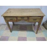 An antique pine writing desk with three drawers