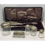 Five hallmarked silver topped bottles along with a cased set of fish servers