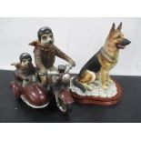 A resin figure group of Meerkats riding a motorbike along with a figure of a German Shepherd