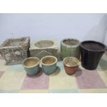 A collection of concrete garden planters and various pots