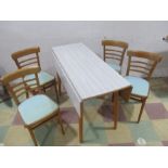 A mid-century drop leaf dining table with four chairs