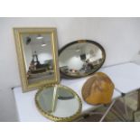 A collection of three mirrors, along with a wooden wall hanging with horse carving