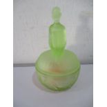 An art deco green glass powder bowl and cover in the form of a seated lady in flapper dress