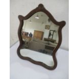 A shaped vanity mirror