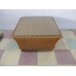A wicker coffee table with glass top