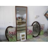 A selection of wall hanging mirrors with wooden frames. Three canvas's and a picture frame.