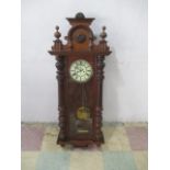 An antique Viennese wall clock with white enamelled dial and Roman numerals.