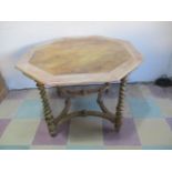An octagonal centre table with marble effect top and glided quatrefoil base