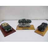 A collection of four model cars including Maisto Aston Martin DB7 Premiere edition 1/18, Burago