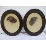 A pair of oval watercolours of ladies in relief with indistinct signatures. Overall height 52cm.