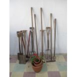 A collection of various garden tools including forks, shapes, rakes etc, along with four