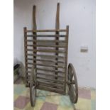The slatted base and pair of wheels of a vintage hand cart