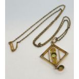 A 9ct gold Art Nouveau pendant and chain set with peridots and seed pearls