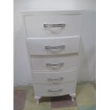 A narrow white painted chest of five drawers