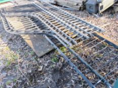 STACK OF ORNATE HEAVY STEEL RAILINGS WITH A PEDESTRIAN GATE.