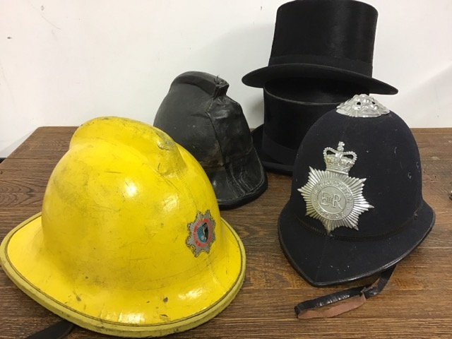 A Metropolitan police helmet together with a 1940s leather fireman's helmet 1980s fibre glass