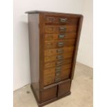 A mahogany Wellington chest, brass and copper handles and plates. Ten drawers with cupboard below.