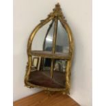 A Georgian gilt corner mirror with shelf decorated with scrolls and shells W:35cm x D:35cm x H: