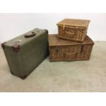 Two wicker hampers together with a canvas suitcase.