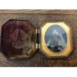 A Victorian Gutta-percha photo frame containing a daguerreotype photo circa 1850.